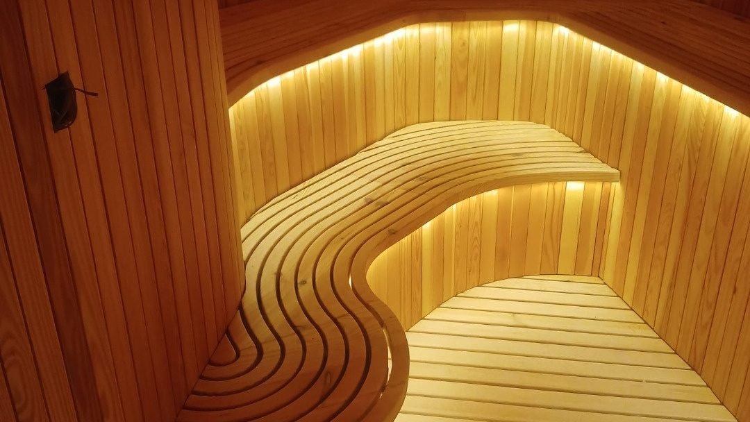 Curved timber sauna benching with concealed LED lighting, St. Regis Al Mouj Muscat